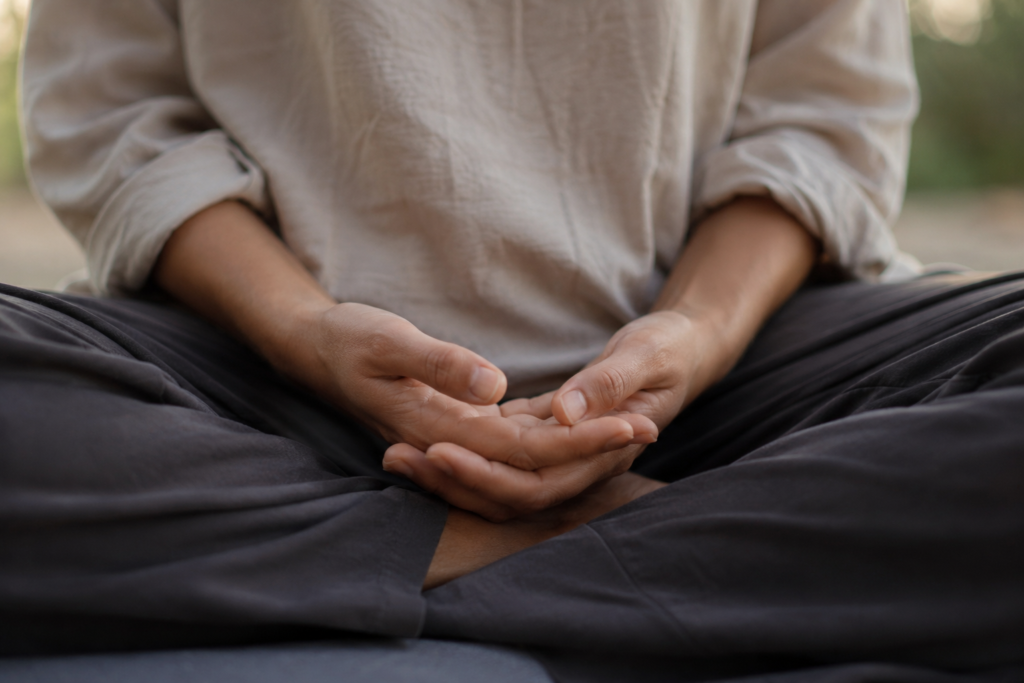Close-up of hands resting in lap during relaxed mindful breathing practice