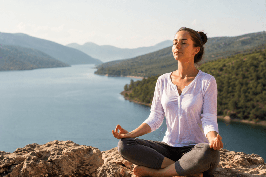Woman practicing mindfulness outdoors while enjoying peaceful present moment awareness and living life to the fullest