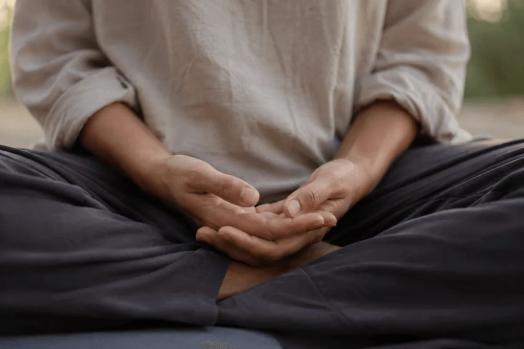 Close-up of hands resting in lap during relaxed mindful breathing practice