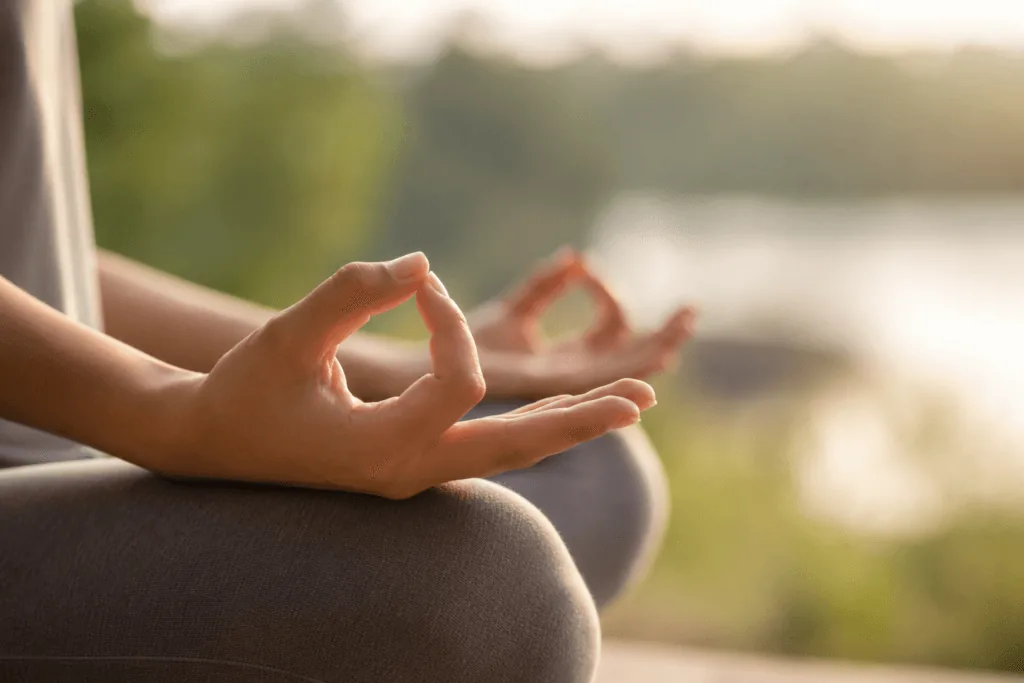Close-up of hands in meditation pose representing present moment awareness practice