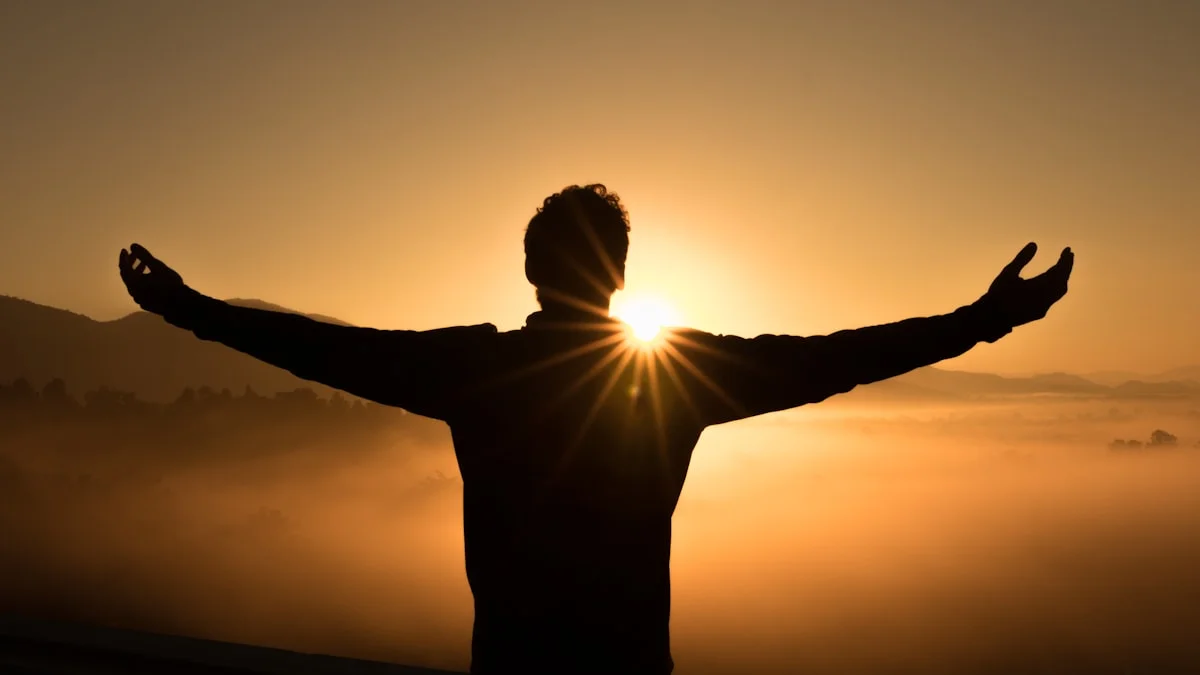 A person standing with arms open in warm sunrise light, suggesting self-acceptance