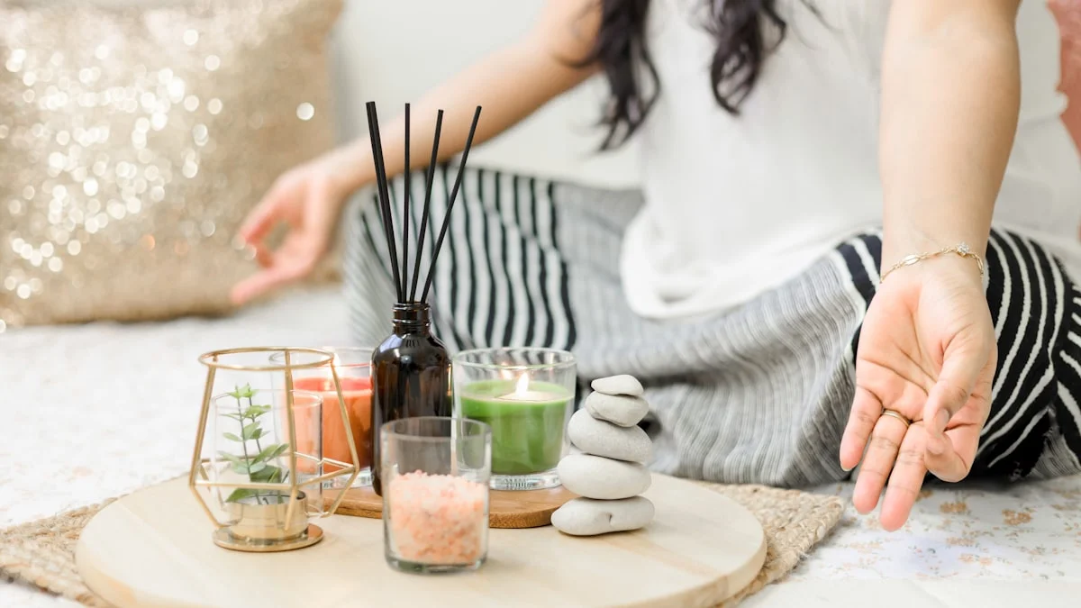 Hands resting beside candles and smooth stones on a small tray